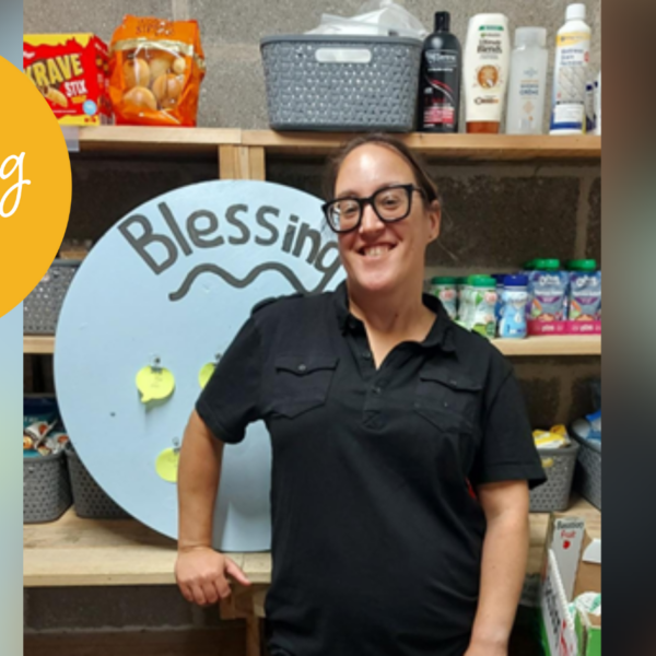 photo of woman smiling in community store, with the generous giving team logo in the top left.