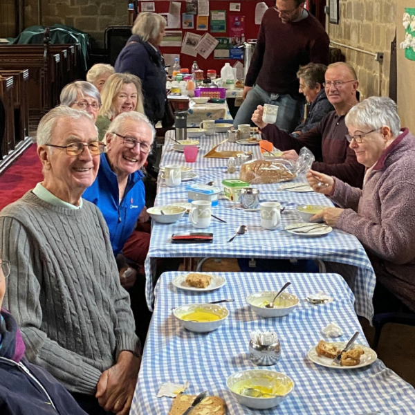 people sat round tables in a church eating lunch