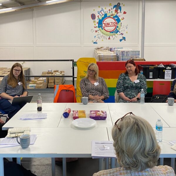 people meeting around a large table in a warehouse