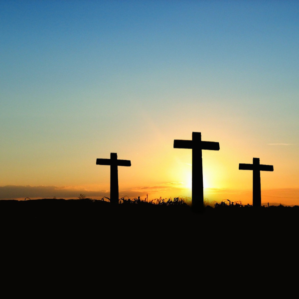 three crosses silhouetted in the sunset